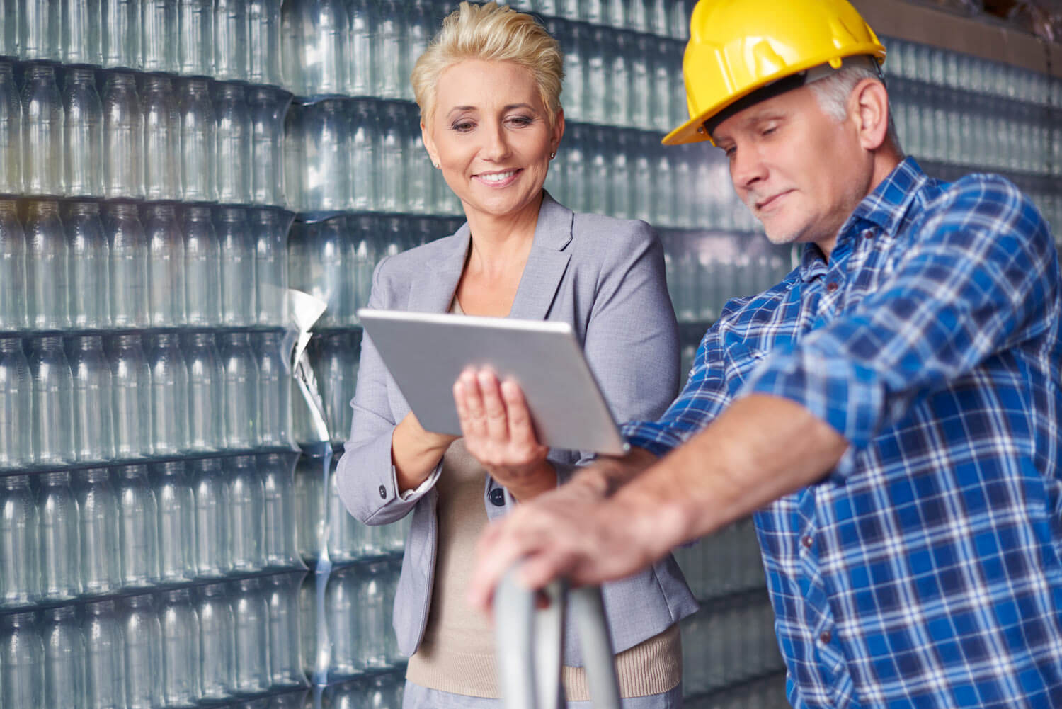 A man and a woman are taking inventory on a tablet using SAP Business One